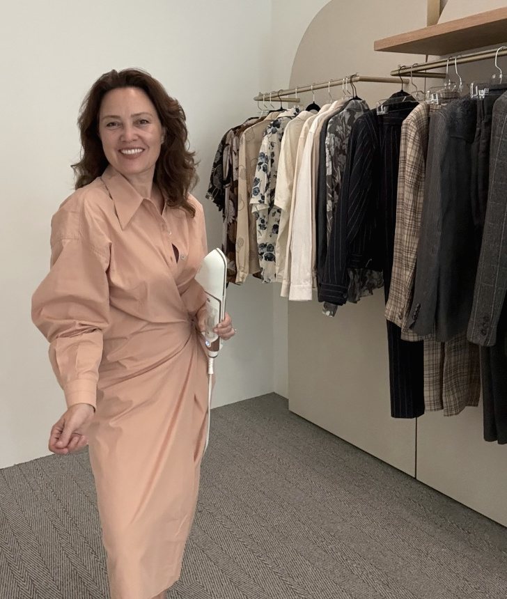 Caroline Rothwell Gerstein in a showroom beside rails of tailoring and printed shirts.